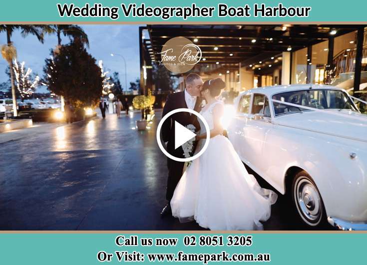 The new couple kissing near the bridal car Boat Harbour NSW 2316